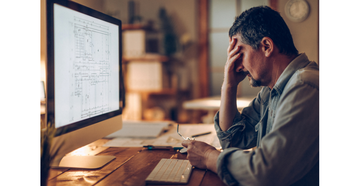 修正地獄の問題が起きてパソコンの画面の前で悩む男性