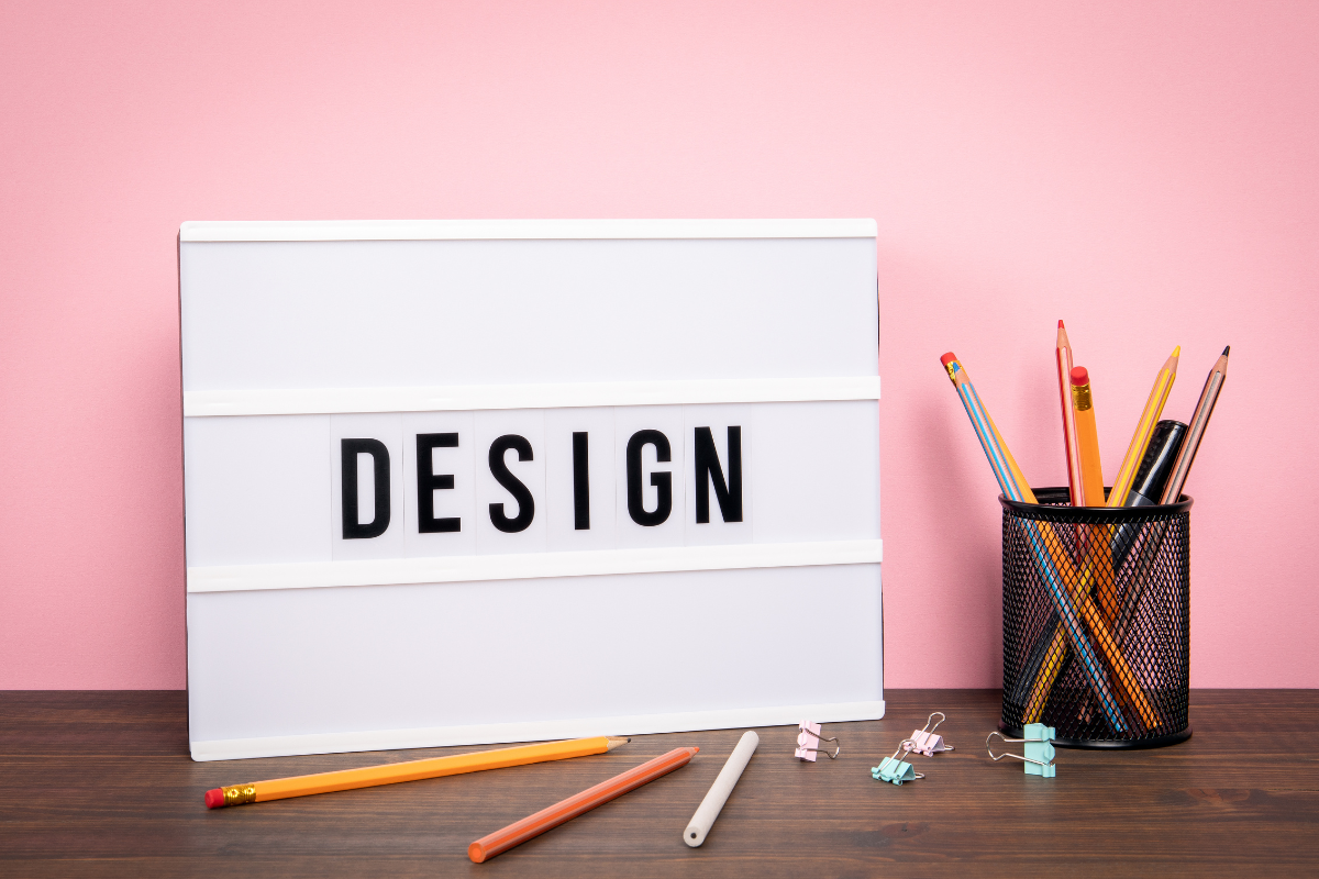 机の上に“DESIGN”(設計)と書かれた白いボードが置かれている